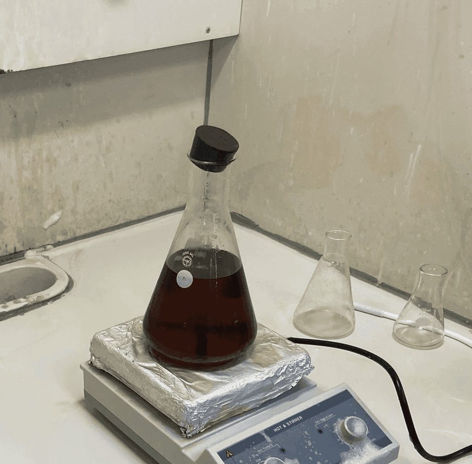 Dark biodiesel in a conical flask on a hotplate stirrer