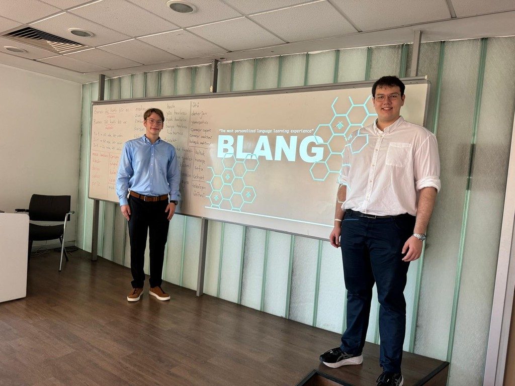 Two founders standing in front of a whiteboard with the BLang logo
