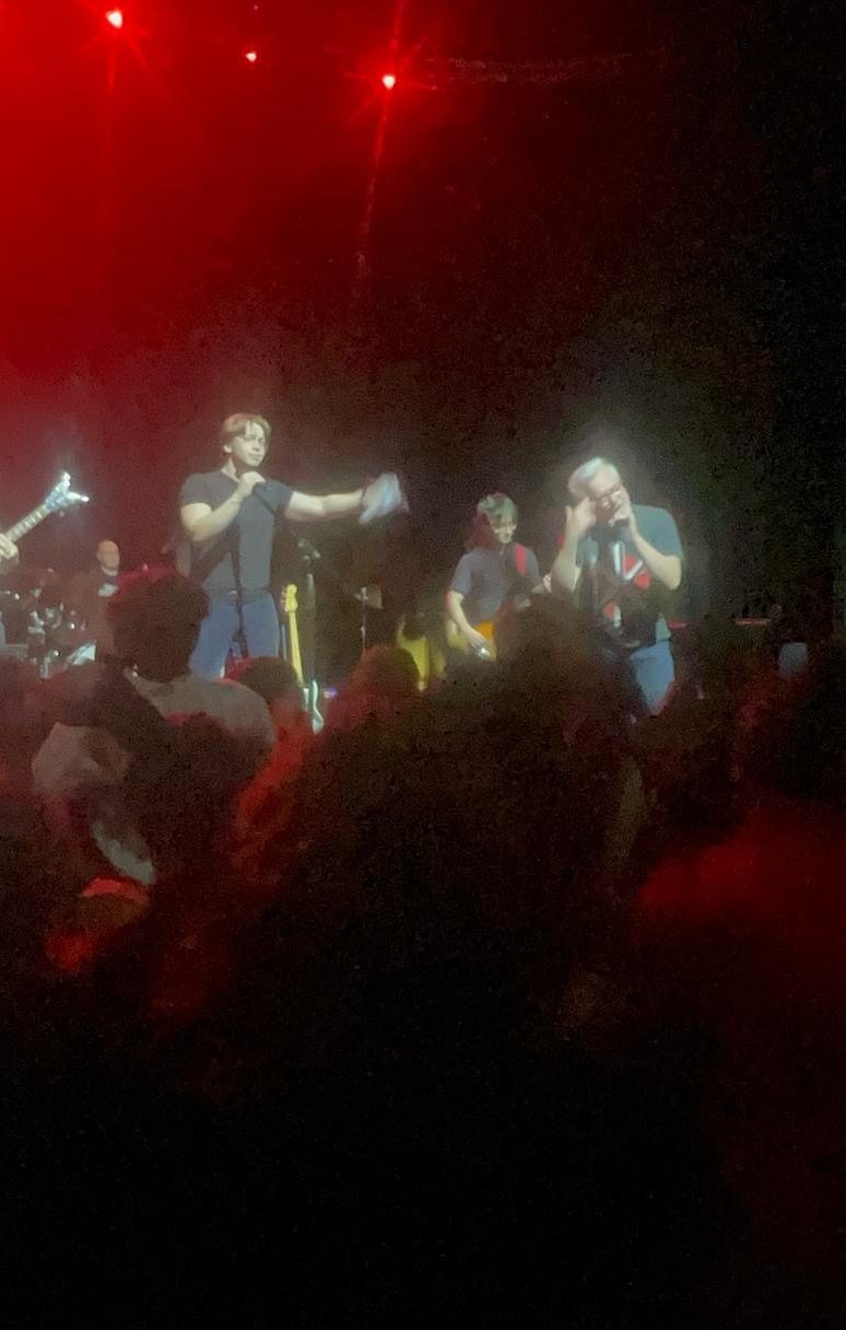 Singing with a band under red stage lights