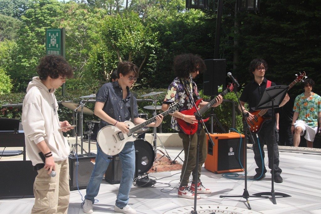 Band performing on an outdoor stage in daylight