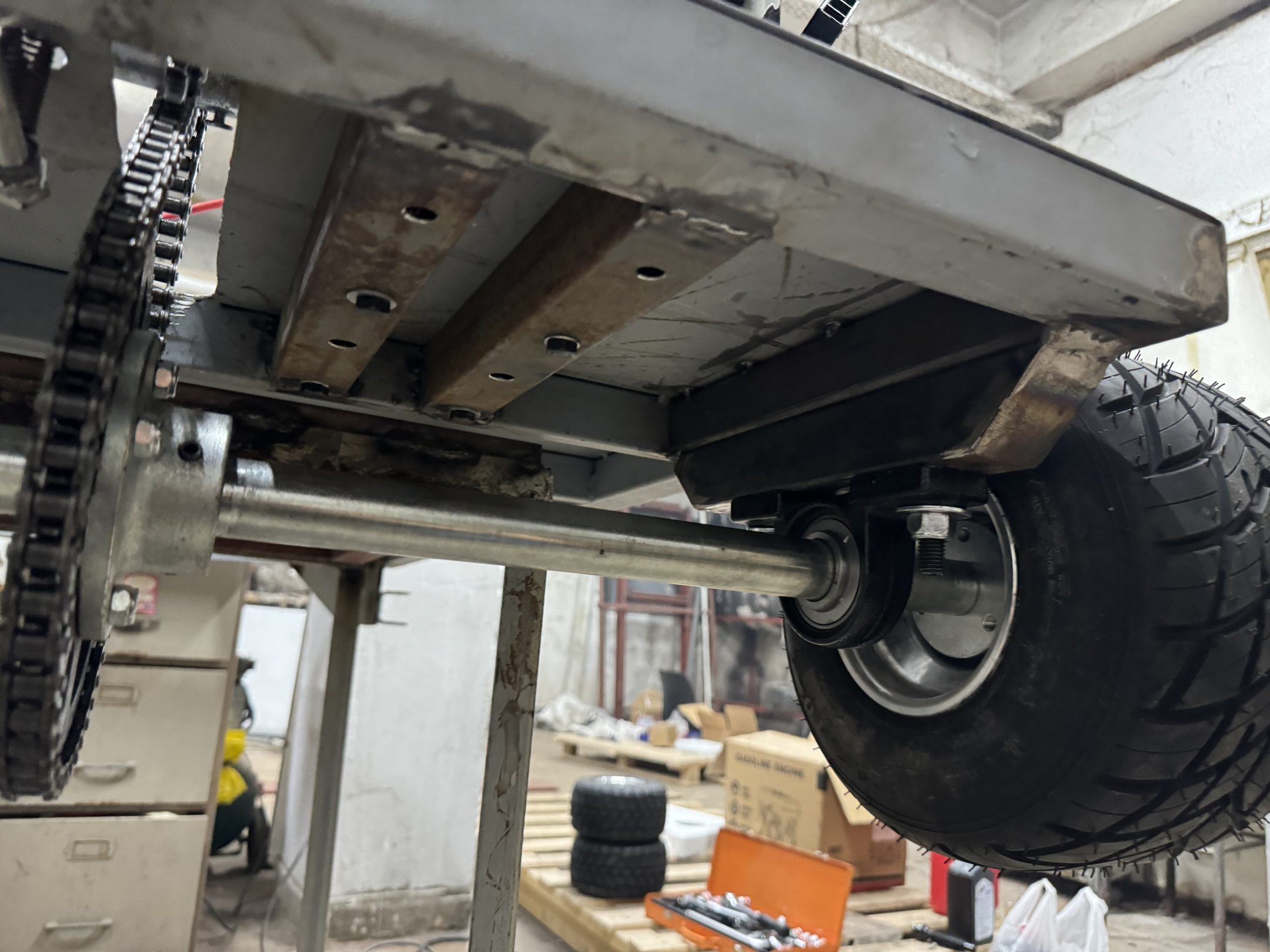 Underside of the kart showing axle, chain and sprocket