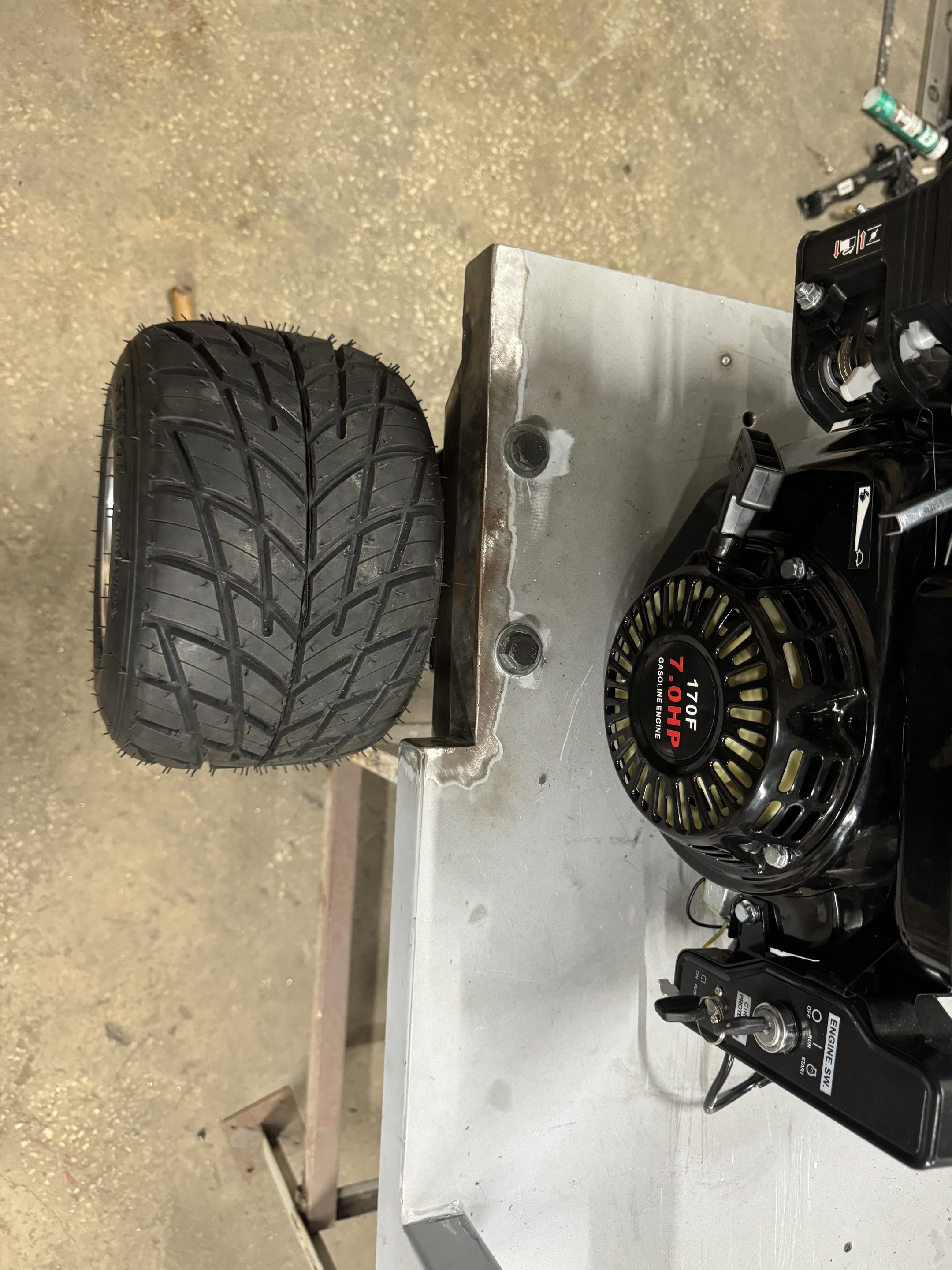 Close view of the 7 horsepower engine recoil starter and a rear wheel