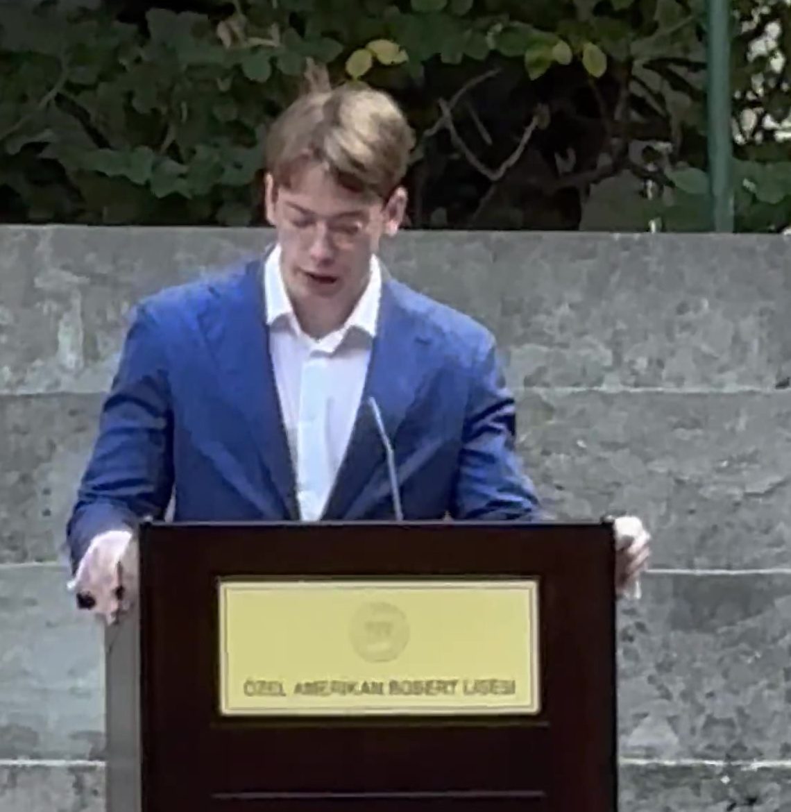 Delivering the opening speech from a lectern in the school amphitheatre