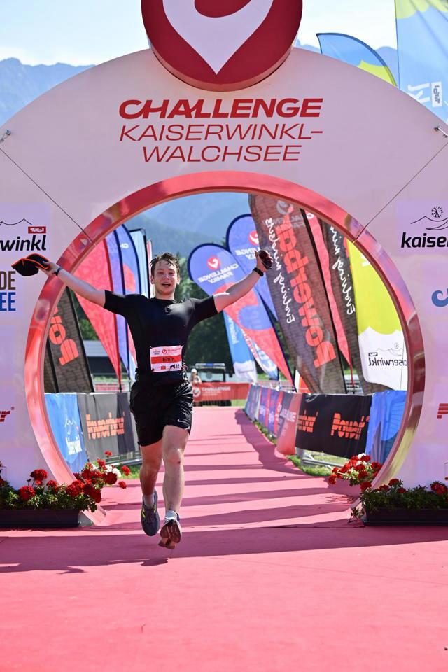 Crossing a triathlon finish line with arms outstretched